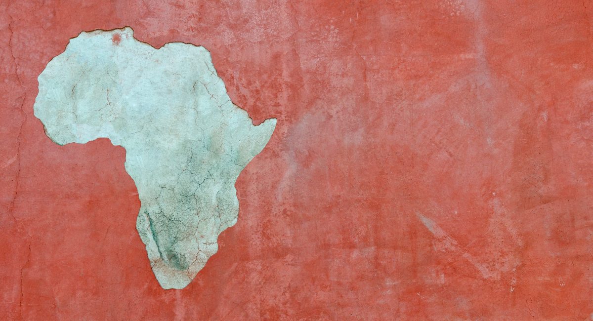 "Red wall background with peeling plaster in the shape of Africa, has great patina"